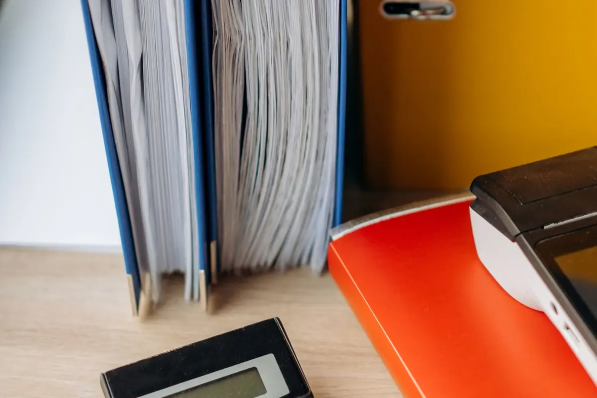 Classeurs et calculatrice sur un bureau, photo d’illustration et non des locaux de MYCRA Fiduciaire